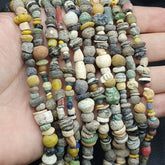 "RM-2: A stunning authentic ancient strand necklace from the Islamic Roman Era, featuring six strands of expertly crafted beads. Each bead tells a story of a bygone era, showcasing intricate designs and patterns that have stood the test of time. A true treasure for collectors and history enthusiasts, this necklace is a rare and precious find."